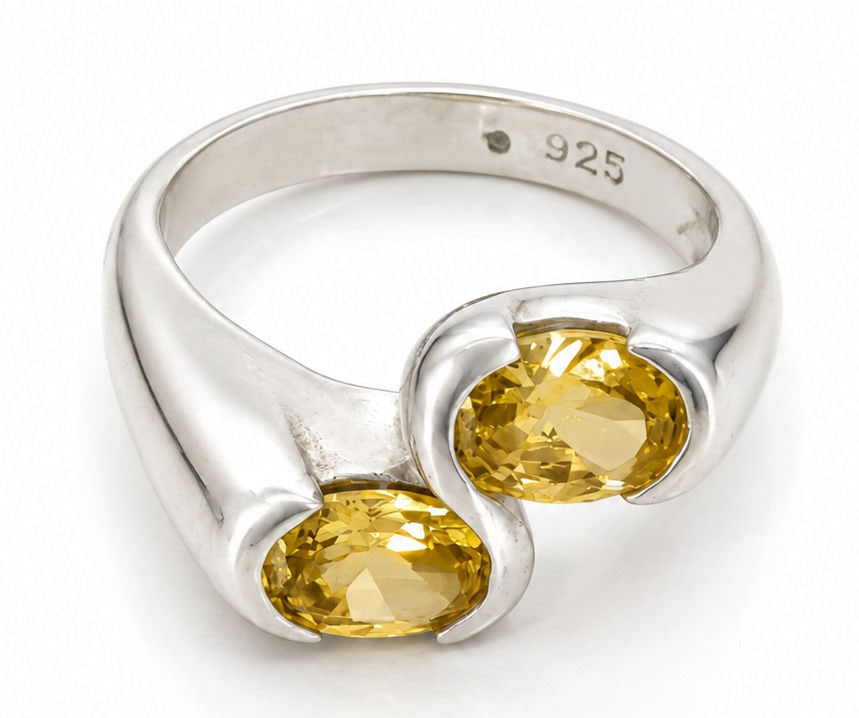 Sterling Silver Open Bypass Ring with Yellow Gemstones: Crafted in sterling silver, this open bypass ring features two oval-cut yellow gemstones in polished bezel style settings. The contemporary design showcases a smooth, tapered shank with an elegant ope