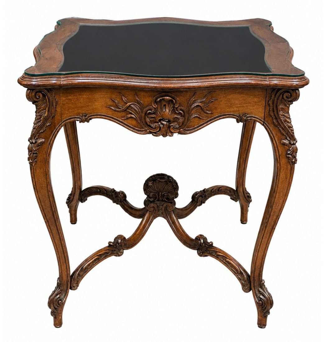 French Rococo Style Carved Wood Glass Top Side Table: A French Rococo style side table featuring a serpentine contoured top inset with a fitted protective glass surface over a warm wood finish. The apron is decorated with deeply carved rocaille shell and