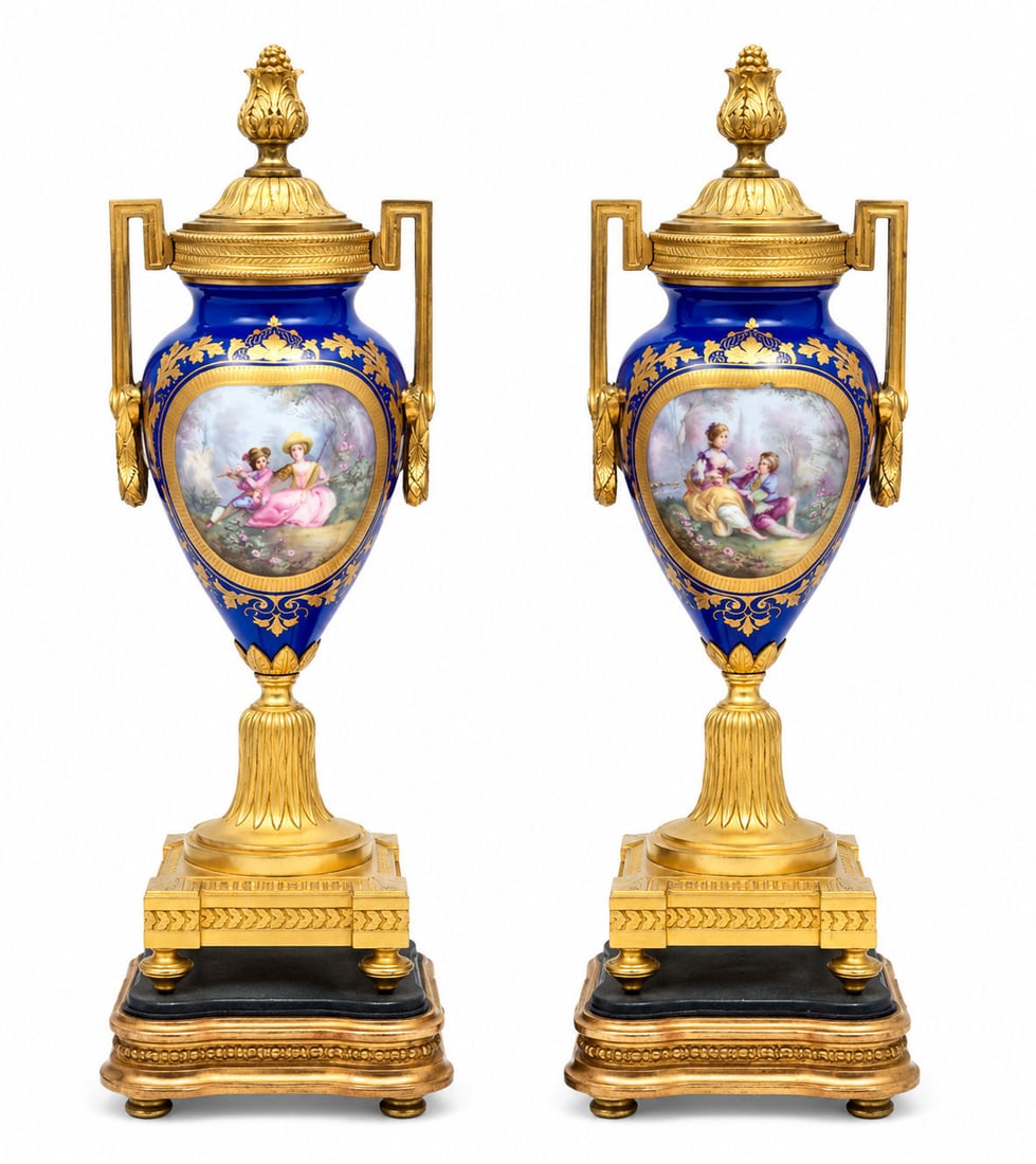 Pair of French Sevres-Style Porcelain Urns with Gilt Bronze Mounts, 19th Century: Exceptional pair of French Sevres-style porcelain urns, richly decorated in deep cobalt blue ground and embellished with finely painted romantic figural scenes within oval reserves. Each urn is accent