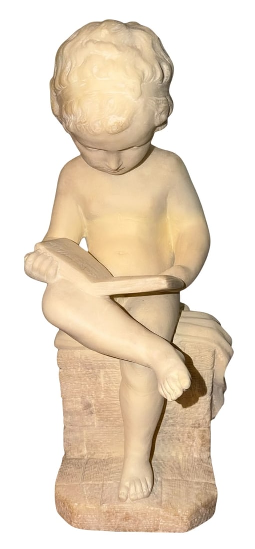 Carved Alabaster Figural Sculpture of a Reading Child: An intricate 19th or early 20th century carved alabaster figural sculpture depicting a young child or cherubic figure seated upon a brick textured plinth. The figure is realistically rendered with sof