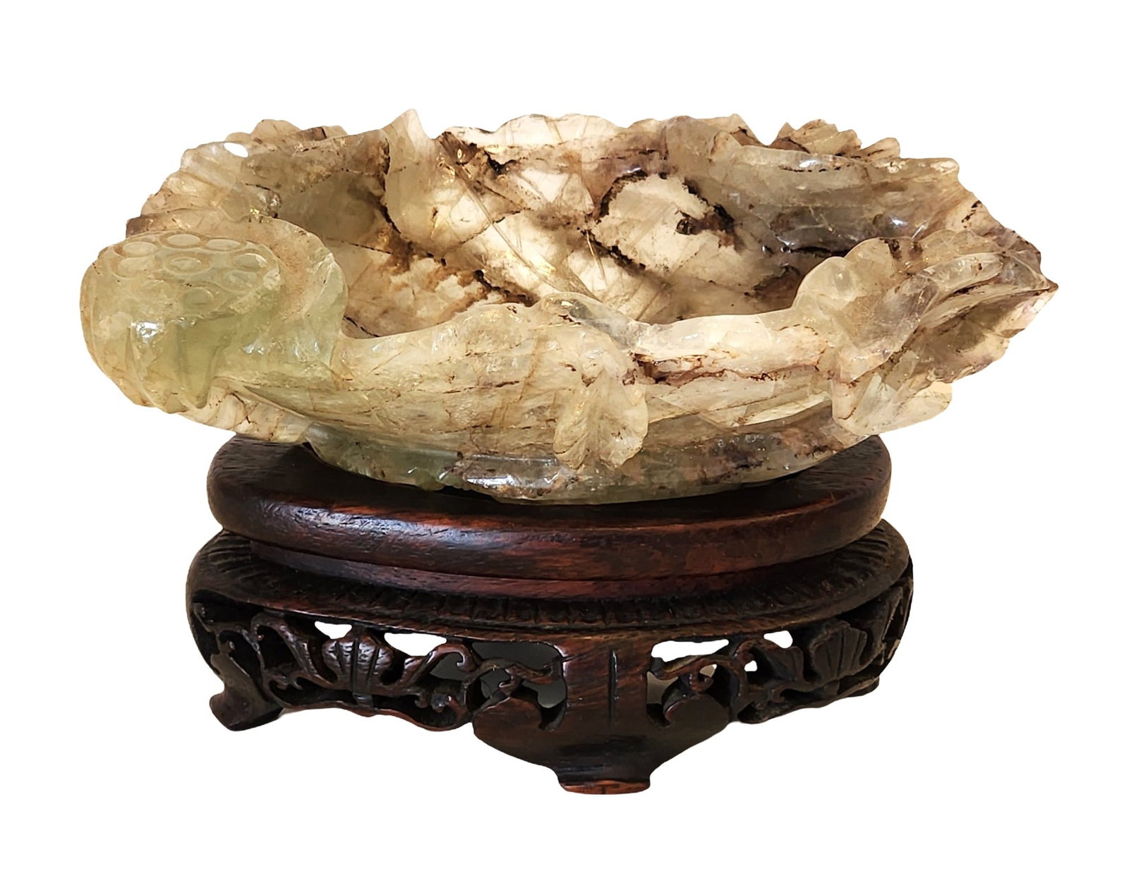 Carved Green Quartz Lotus-Form Bowl with Wooden Stand: Hand-carved green quartz bowl in an organic lotus or leaf form, featuring textured carving and natural internal inclusions characteristic of the stone. The quartz displays varied tones from pale green