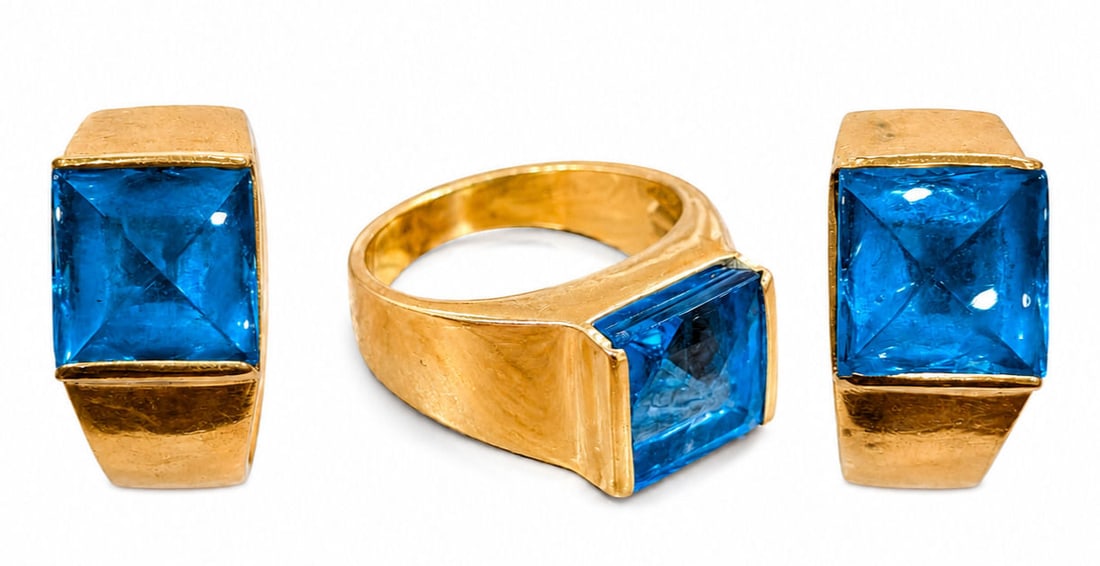 18K Yellow Gold & Sugarloaf Topaz Ring with Matching Earrings Suite: An impressive 18K yellow gold jewelry suite featuring a wide statement ring and a pair of matching clip on earrings. Each piece is set with a vibrant, square sugarloaf cabochon cut blue topaz with pyr