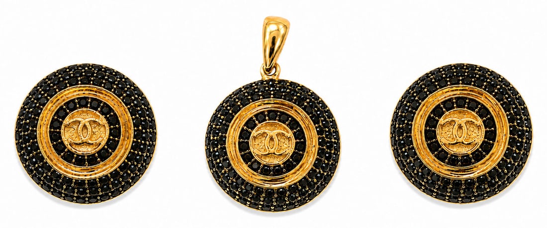 Chanel Style Gold-Tone Black Spinel / Rhinestone CC Logo Clip Earrings & Pendant Set: An elegant three piece fine fashion jewelry set featuring a matching pendant and pair of clip on post earrings in a domed circular design. Each piece is set with concentric rings of pav? black stones 
