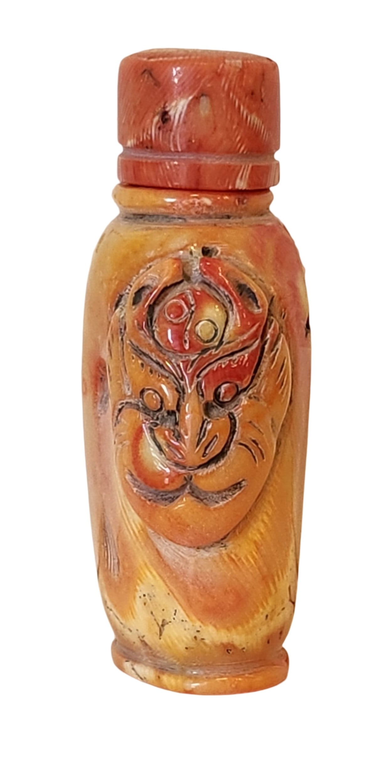 Antique Carved Red Coral Snuff Bottle with Mask Motif, 20th Century: A finely carved red coral snuff bottle with a stylized mask motif in relief on the body, highlighted with traces of pigment. The coral stopper includes its original spoon. The bottle exhibits natural 