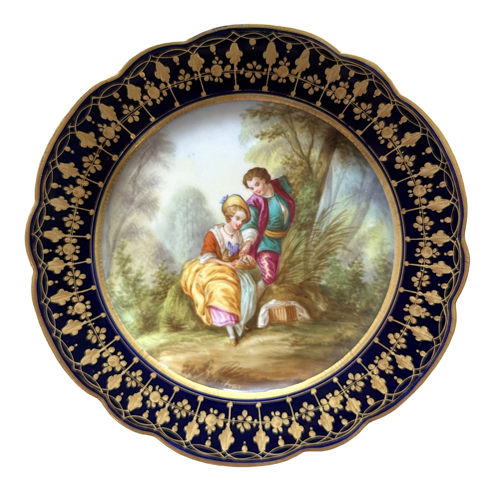 French Sevres Hand-Painted Porcelain Plate with Cobalt Border, Signed Boucher: Elegant French Sevres porcelain cabinet plate featuring a beautifully hand-painted romantic scene of a couple seated in a lush garden landscape. The finely detailed artwork is signed "Boucher" on the 