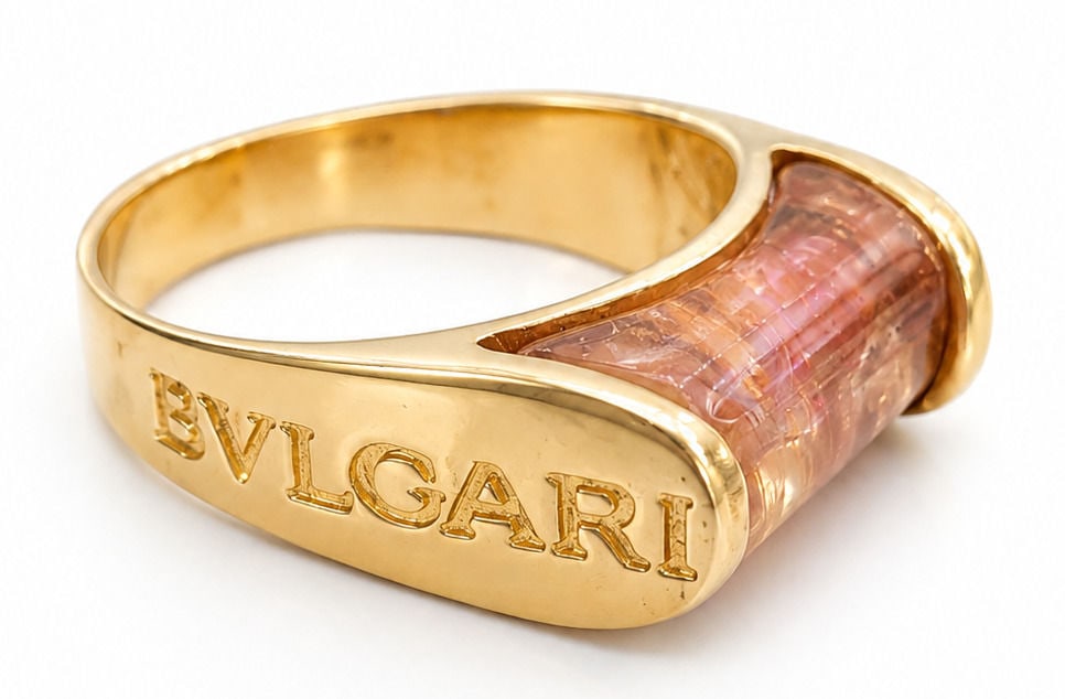 14K Yellow Gold Citrine / Topaz Ring in the Style of Bvlgari: This bold 14K yellow gold statement ring features a central horizontal cylinder-cut amber gemstone?such as citrine, topaz, or tourmaline?held securely within a thick gold end-cap bezel setting. The fl