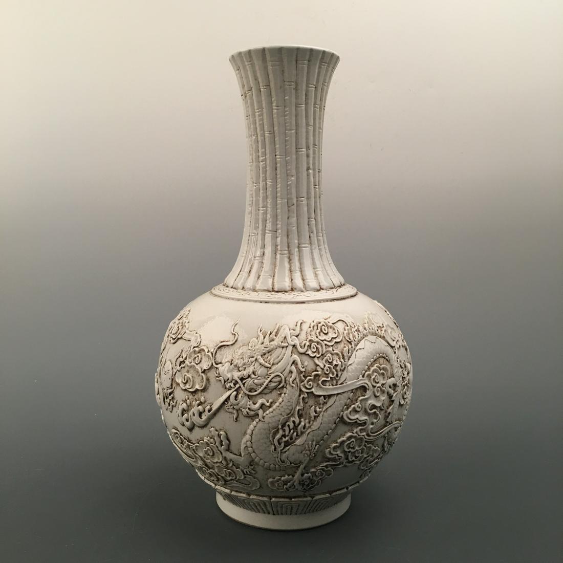 Chinese White Glazed Engraved 'Dragon' Bottle Vase: Chinese White Glazed Engraved 'Dragon' Bottle Vase 16'' H, 8-1/4'' W; 8.4 lb Shipping: We are able to pack and ship this item to an address in the United States for $35.00 via UPS Ground or USPS Prior