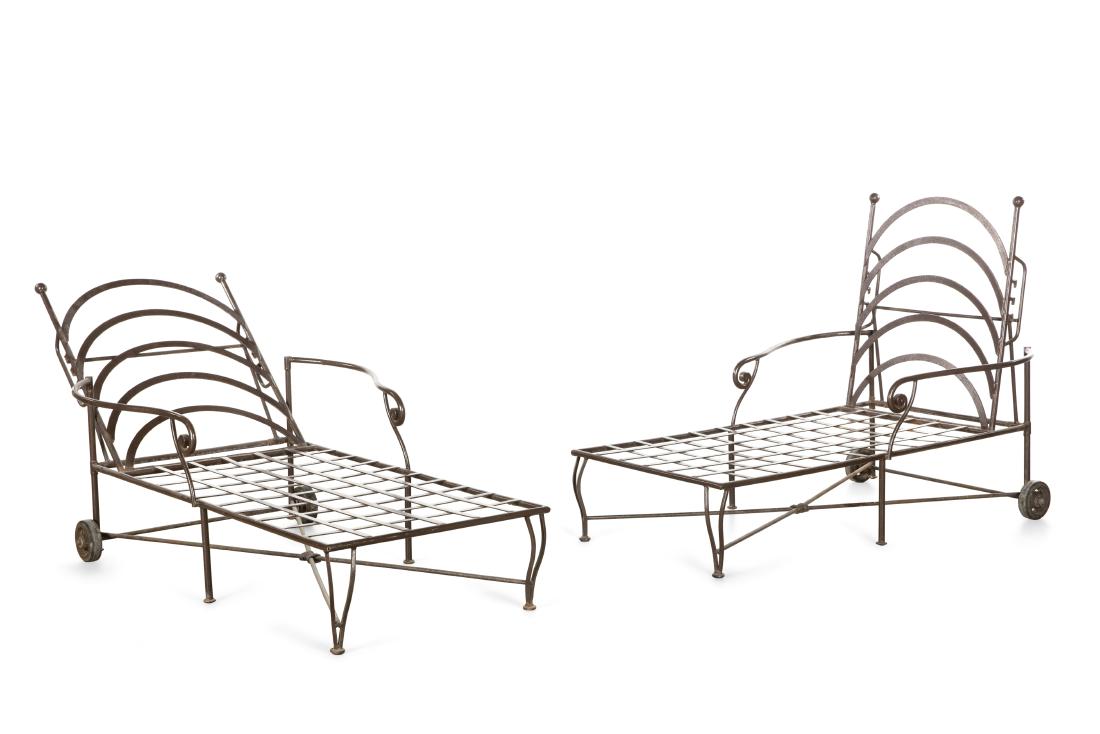 A pair of wrought iron adjustable chaises longue: A pair of patinated wrought iron adjustable chaise longue post 1950 height 40 1/2in (103cm); width 36 1/4in (92cm); length 69in (175.5cm)