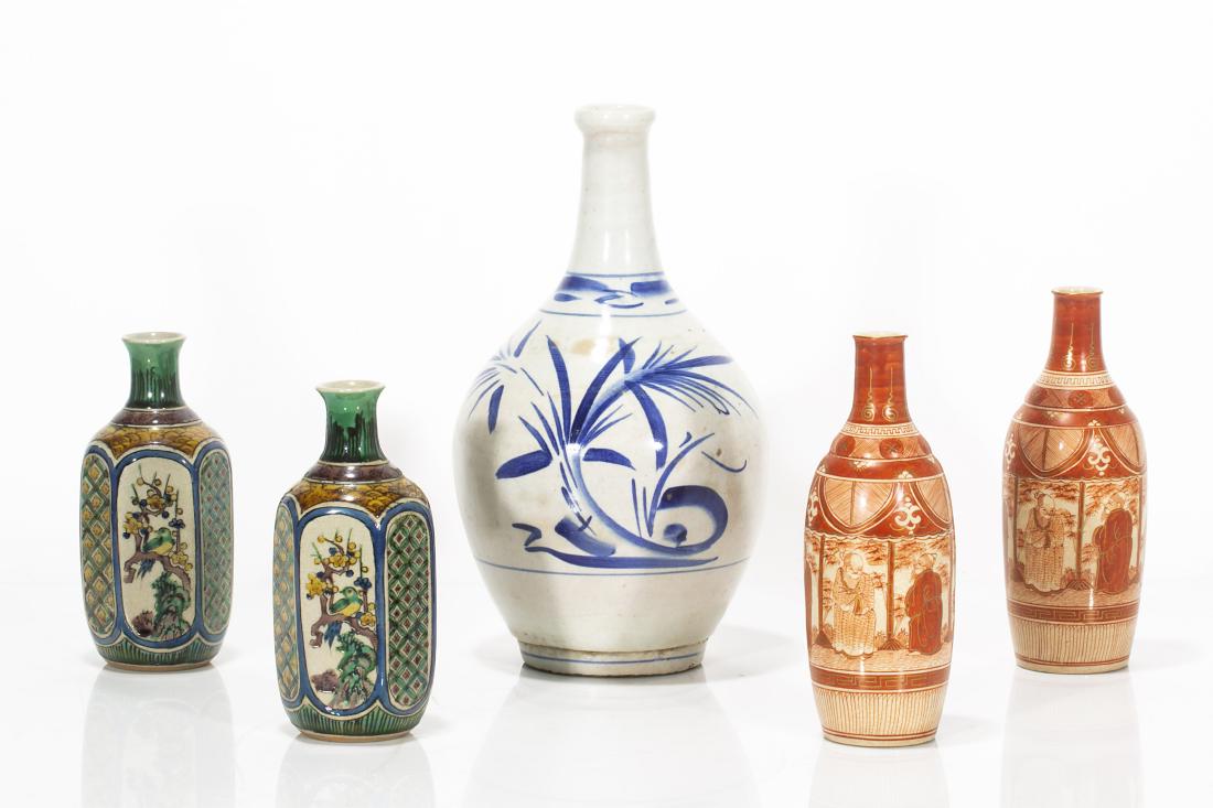 A group of five Japanese porcelain sake bottles: A group of five Japanese porcelain sake bottles Late Meiji Period and later Comprising two pairs of Kutani bottles and a blue and white bottle. the largest height 10 1/2in (27cm)