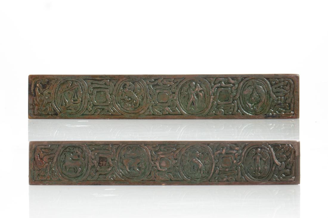 Pair of Tiffany Studios Zodiac blotter ends, 994: A pair of Tiffany Studios Zodiac pattern patinated bronze blotter ends 1899-1918 #994 length 12 1/4in (31cm)
