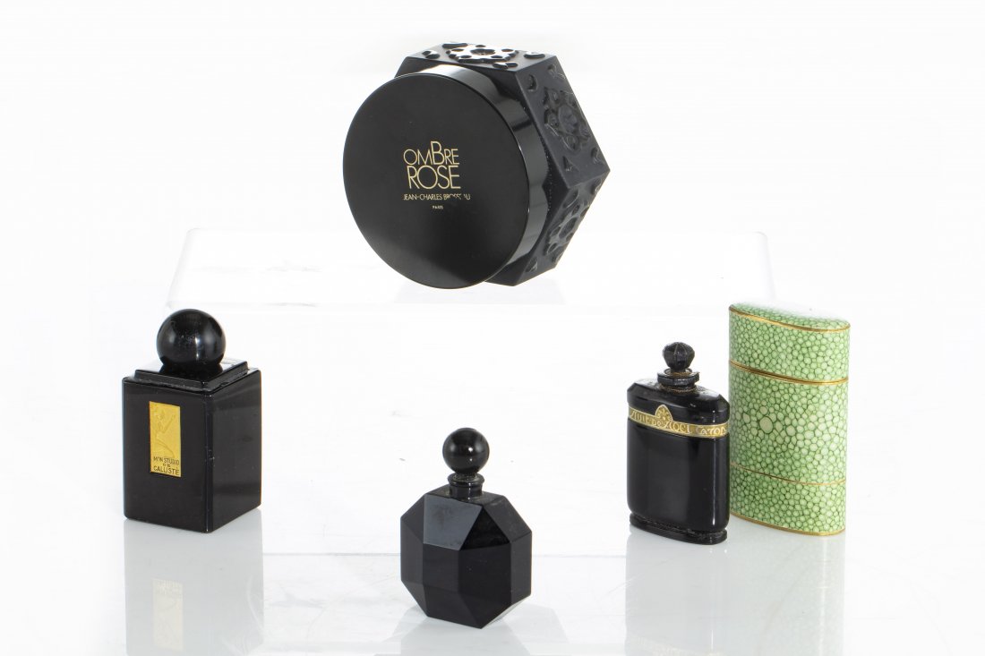 Four French black glass perfume bottles, Caron: Four French black glass perfume bottles 20th century One for Caron, with faux shagreen case, one for Mon Studio de Calliste, one octagonal and a jar for Ombre Rose J.C. Brousseau. the jar height 2 1/4
