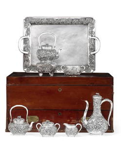 A Japanese silver chrysanthemum tea service: A Japanese silver six piece chrysanthemum decorated tea service with matching two-handled tray Arthur & Bond, Yokohama early 20th century Comprising a kettle-on-stand, a tea pot, a coffee pot, a cream