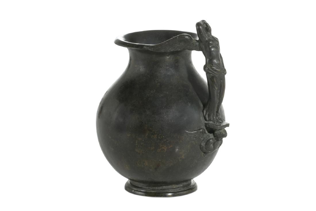 An Italian patinated bronze jug: An Italian patinated bronze jug with figural handle height 7 1/2in (19cm); width 5 1/2in (14cm)Provenance: Property from the Estate of Jack Levin, Los Angeles, California.