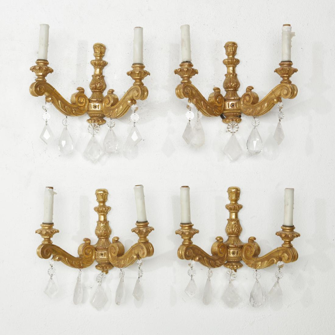 Four giltwood and rock crystal wall lights: A set of four Continental Neoclassic style giltwood and rock crystal twin branch wall lights modern height 14in (35.5cm); width 14in (35.5cm)