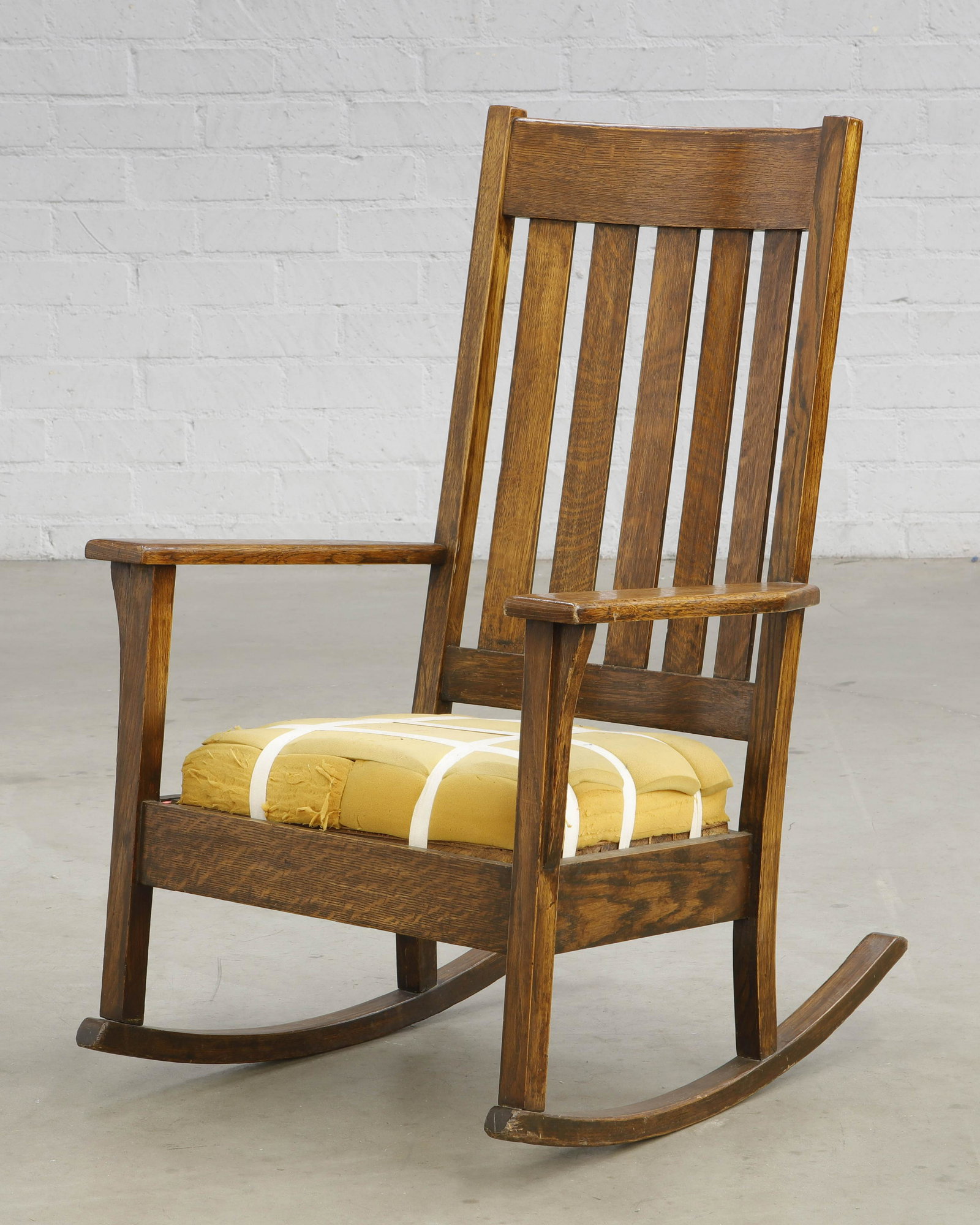 An Arts & Crafts oak rocking chair: An Arts & Crafts oak rocking chair National Chair Company, St. Louis, Missouri first half 20th century With an applied paper label to the seat frame. height 41 1/2in (105.5cm); width 26 1/4in (66.5cm)