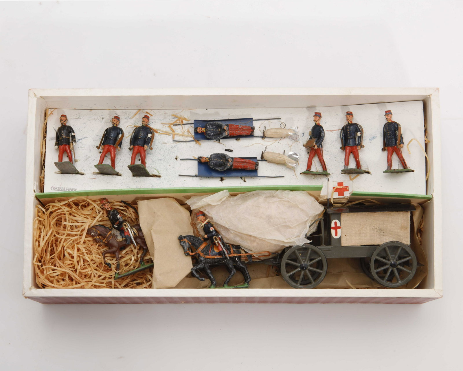 A German "French Ambulance" set in original box: A German polychromed tin and lead "French Ambulance" set in original box Retailed by F.A.O. Schwarz, New York City In original box and packaging with applied paper retailers label. height 2 1/2in (6cm