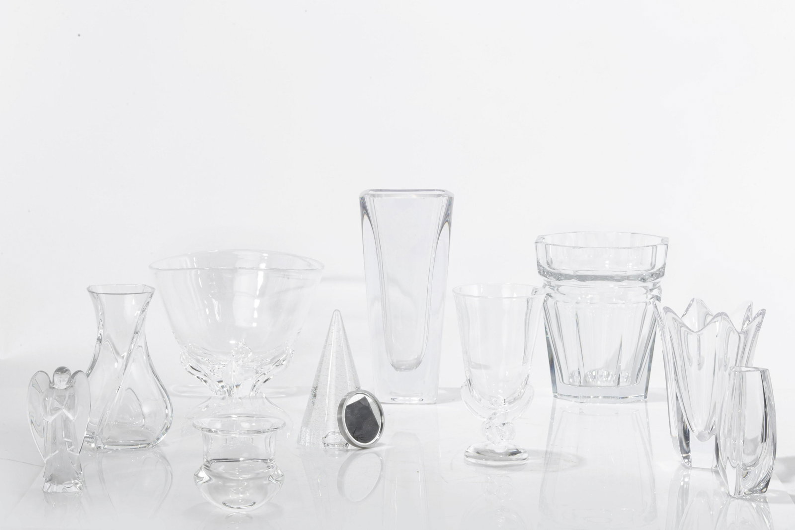 Ten clear glass table articles, Baccarat, Orrefors: A collection of clear glass table articles Comprising two Baccarat vases, figure of an angel and a wine cooler in the Moulin Rouge pattern (lacking handles), etched factory marks; two Steuben vases, c