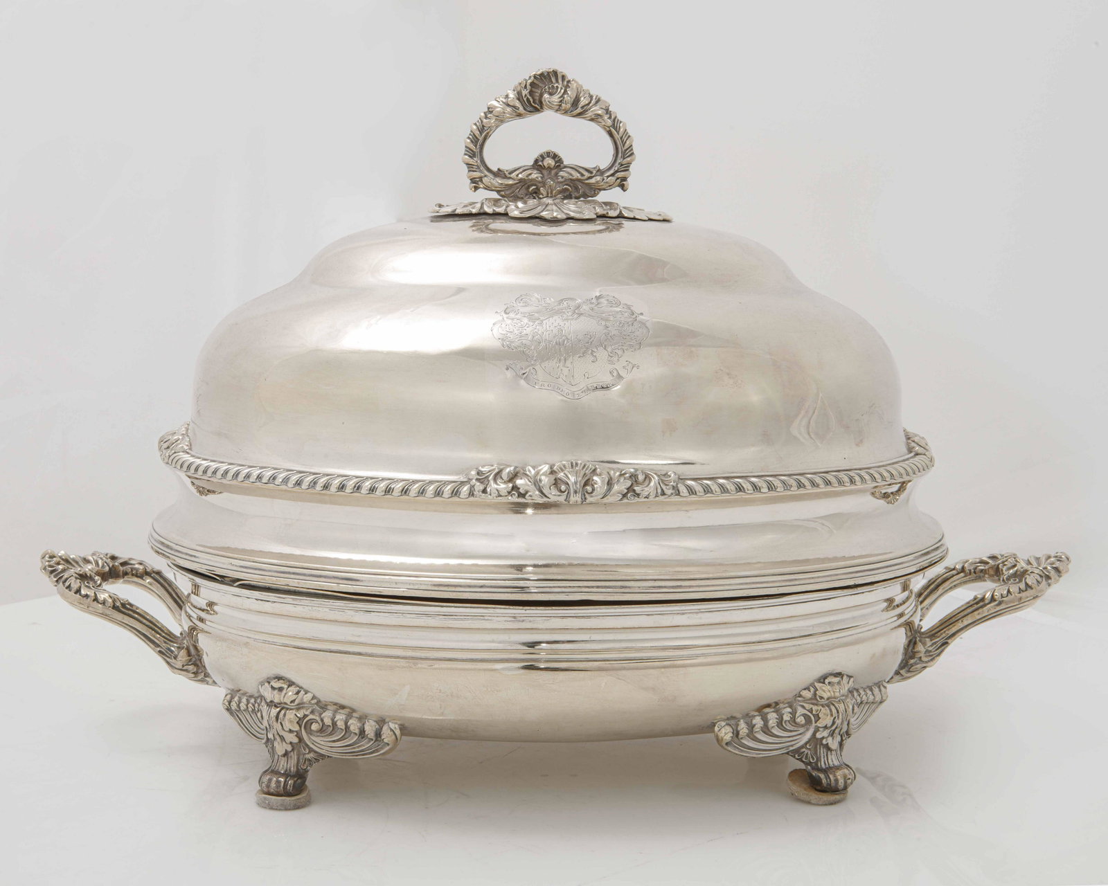 A Sheffield plate oval meat dish & cover, Boulton: A Regency Sheffield plate oval meat dish and cover Matthew Boulton, Birmingham first half 19th century Engraved with a coat of arms and motto PRO DEO ET REGE. height 13in (33cm); width across the hand