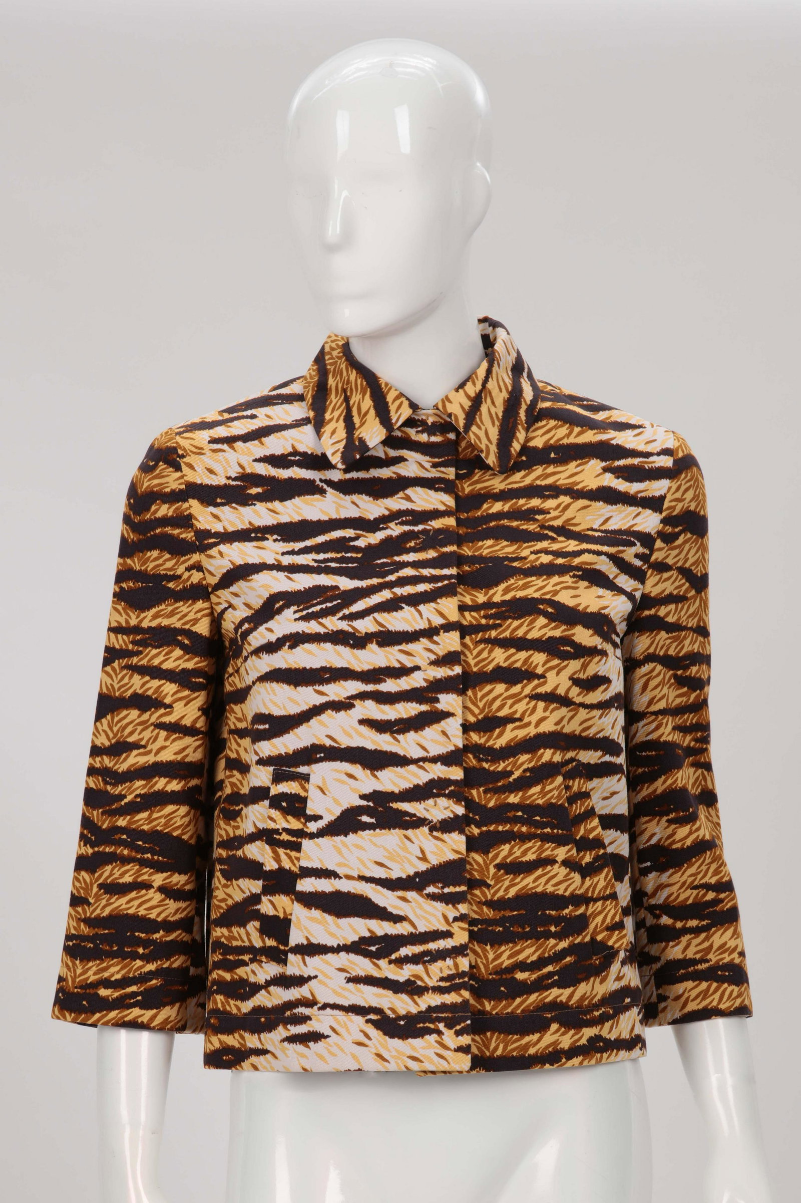 A D & G tiger print cropped jeans jacket: A D & G brown, gold and black tiger print cropped jeans jacket, size 30/44 1990s This cotton short jacket with snap closure front, 3/4 sleeves with snap wrist and diagonal pockets at hips.