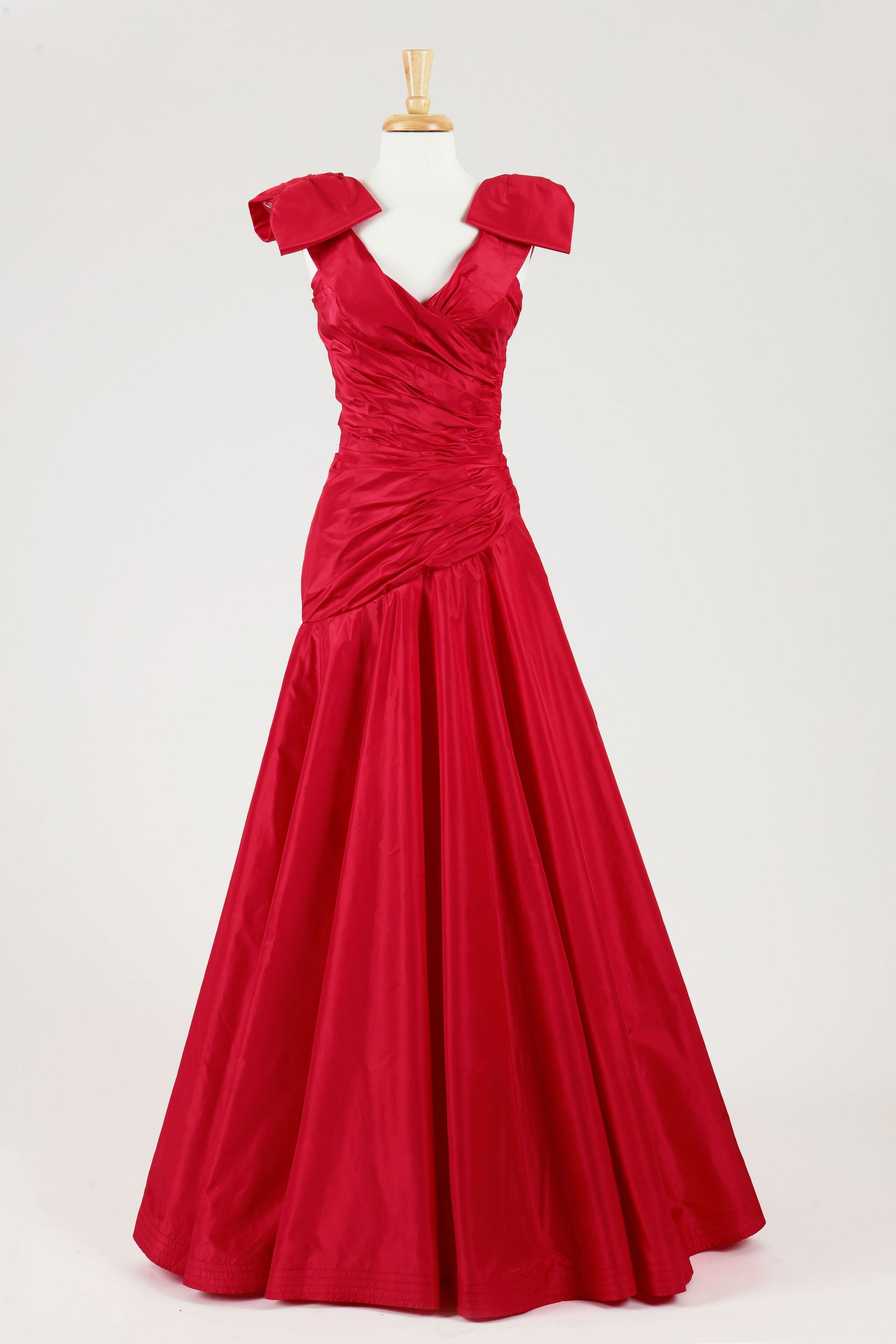 A Murray Arbeid red ruched taffeta gown: A Murray Arbeid red ruched taffeta gown 1980s Low curved bustline with off the shoulder bow detail at shoulders. The ruched fitted waist with diagonal shape to hip and a well shaped skirt and crenilan