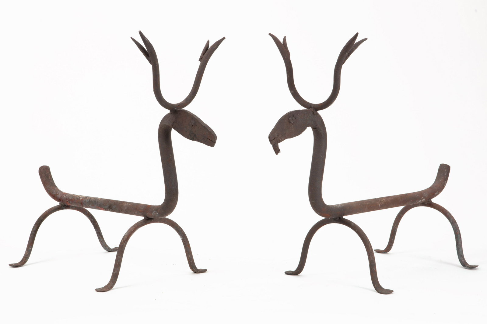 A pair whimsical wrought iron stag form andirons: A pair whimsical wrought iron stag form andirons first half 20th century height 19in (48.5cm); width 10 1/2in (26.5cm); depth 24 1/2in (62cm)Provenance: Property from The McNally Company Antiques, Ran