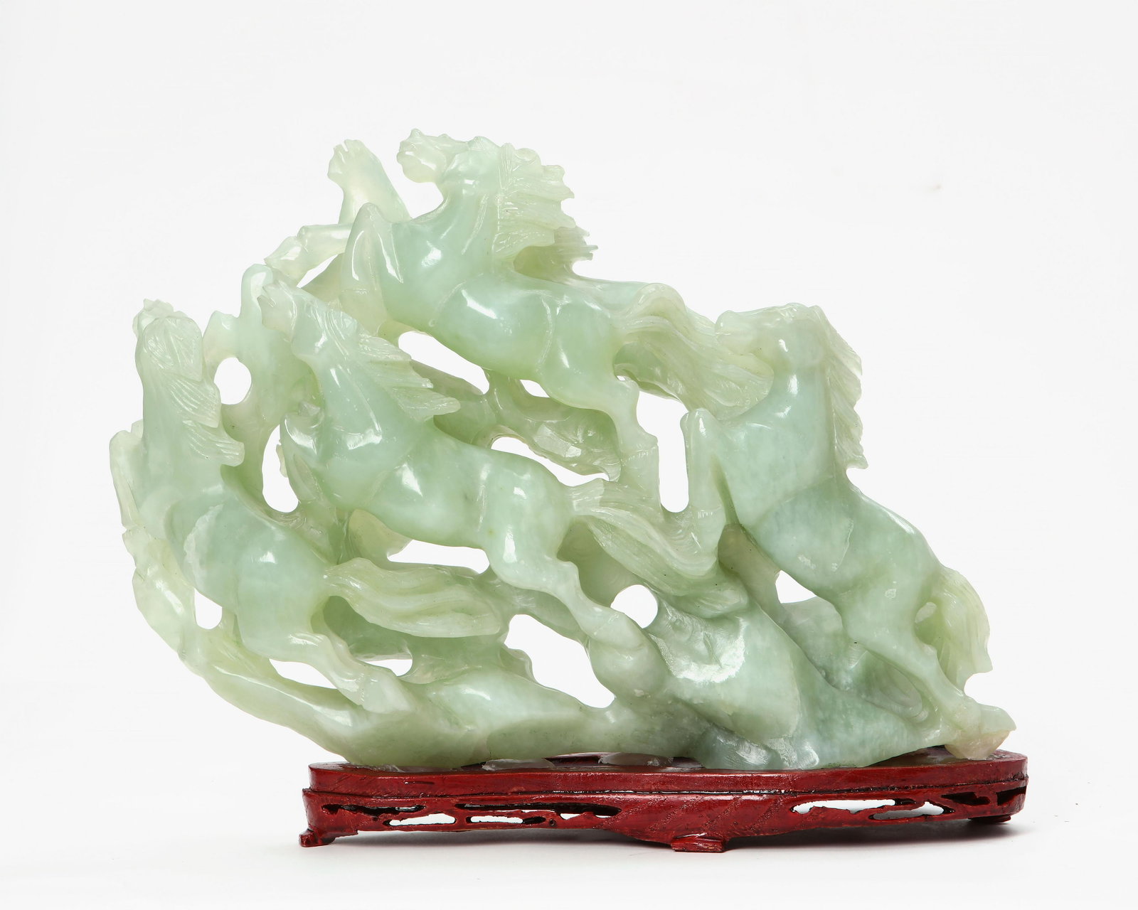 Chinese green hardstone carving of leaping horses: A Chinese green hardstone carving of leaping horses On stand. overall height 10 1/2in (26.25cm); width 13 1/2in (34.25cm) Provenance: Property from the Collection of Yasuko and Maury Kraines.