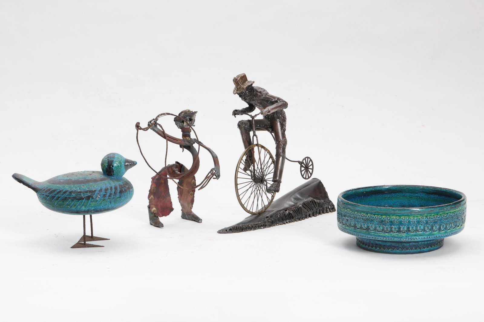 Four Modernist ceramic & metal table decorations: Four Modernist ceramic and metal table decorations mid 20th century Comprising an Illums Bolighus bowl, and Italian model of a duck, a mixed metal assemblage of a cowboy and a Ralph Starritt model of 