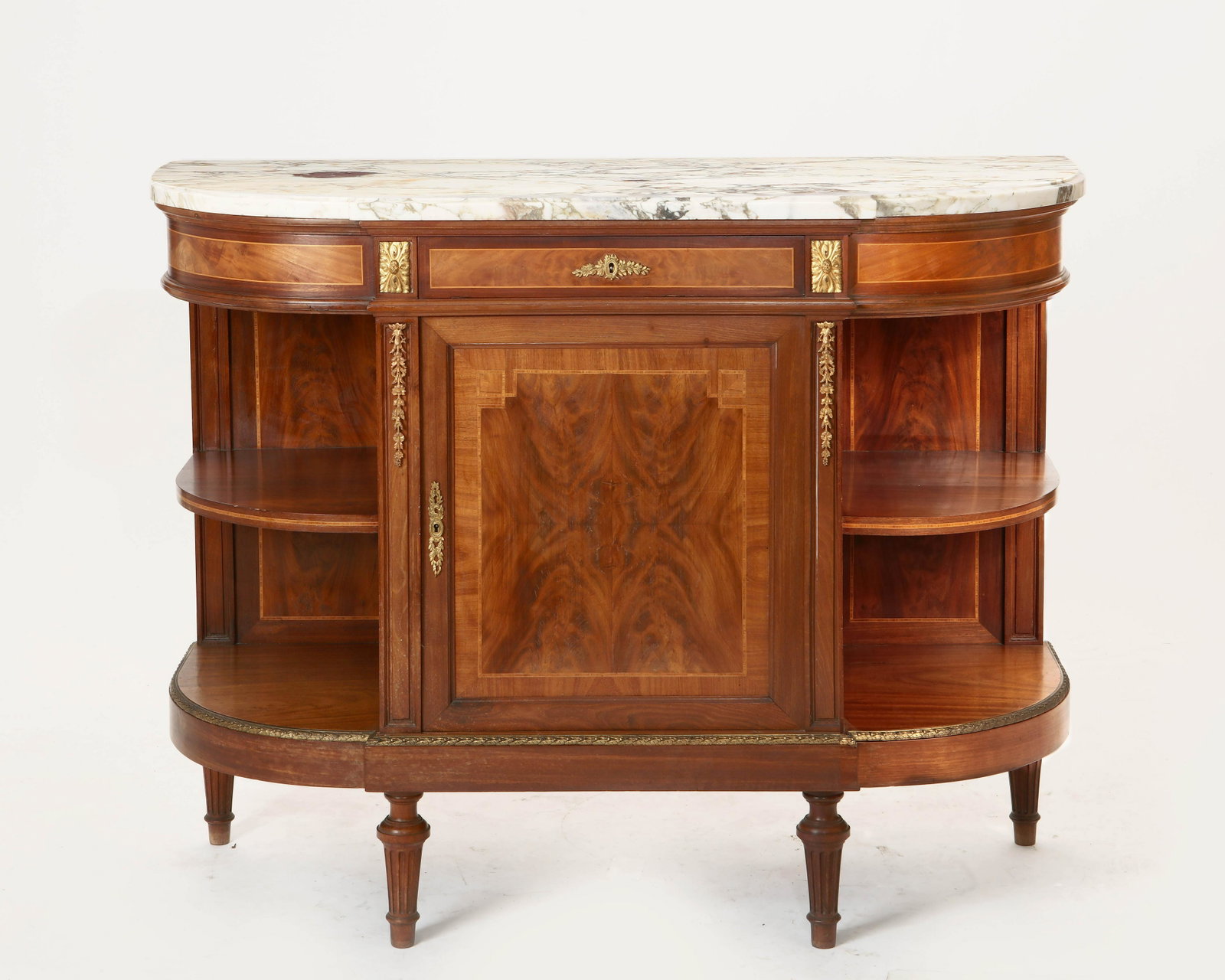 A Louis XVI style walnut and mahogany buffet: A Louis XVI style gilt bronze mounted inlaid walnut and mahogany buffet late 19th century Surmounted by a marble top. height 58 3/4in (149.5cm); width 51in (129.5cm); depth 20in (51cm)