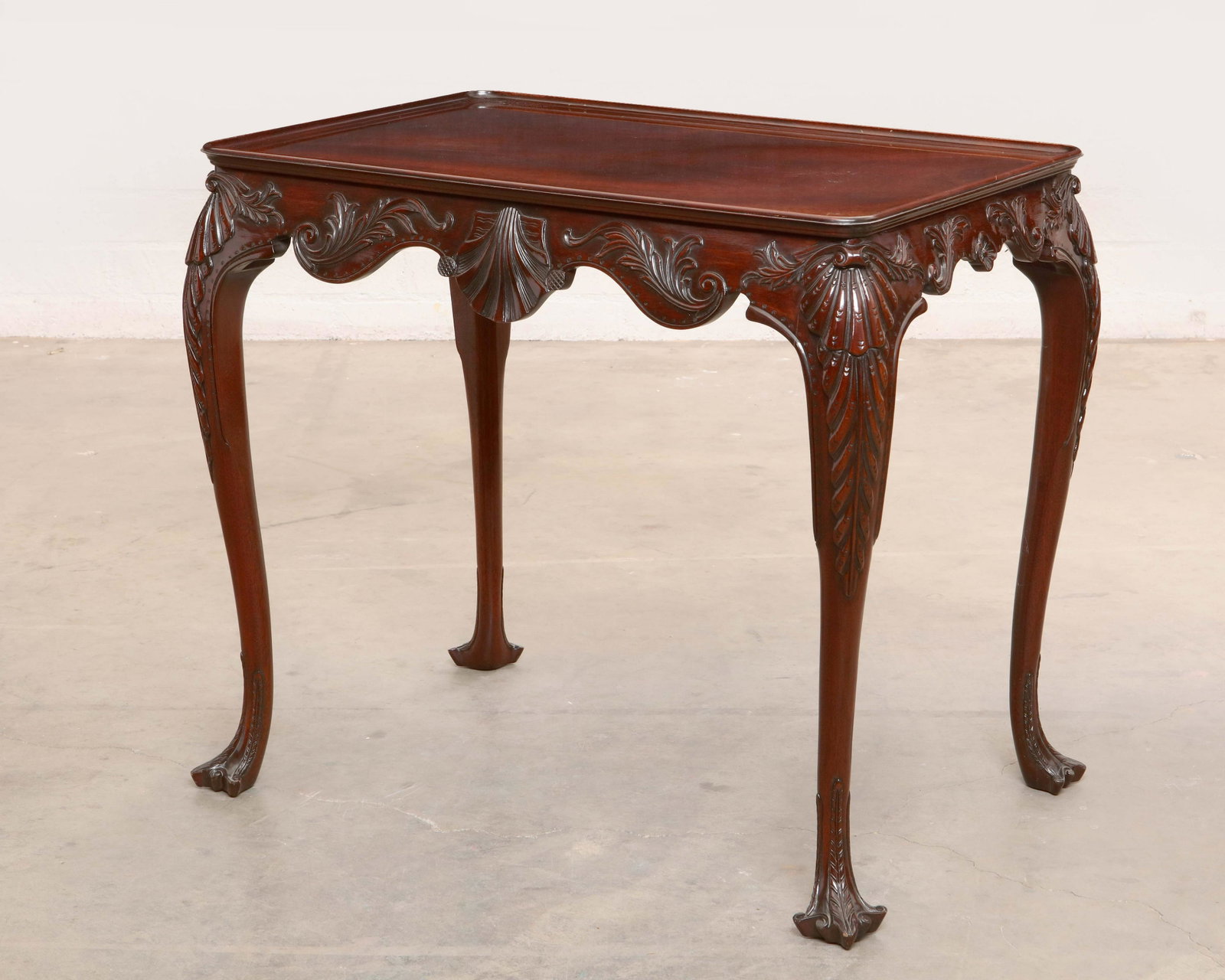 A Kindel Irish Georgian style mahogany table: A Kindel Irish Georgian mahogany tea / center table post 1950 With maker s plaque to underside and stamped IRISH GEORGIAN and numbered 84 803 24 height 29in (73.5cm); width 33in (84cm); 22in (56cm) Pr