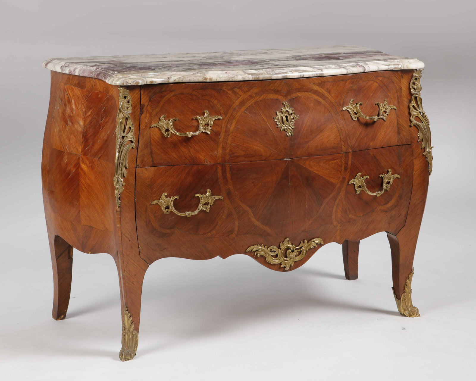 A Louis XV style gilt inlaid walnut commode: A Louis XV style gilt bronze mounted inlaid walnut commode early 20th century Surmounted by a breche violette marble top. height 34 3/4in (88.5cm); width 47 3/4in (121.5cm); depth 22 1/2in (57cm)
