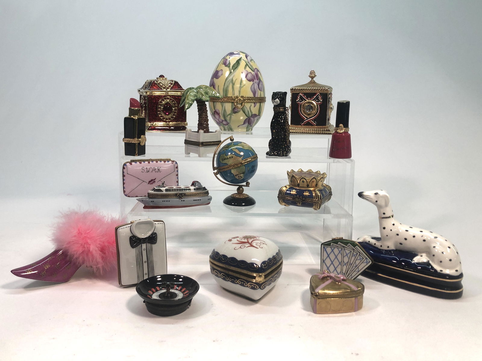 Fifteen Limoges porcelain boxes and articles: A collection of fifteen Limoges porcelain boxes and articles Together with two Wendy Reed enamel and gilt metal boxes and a Fitz and Floyd model of of a Dalmatian. (18) dimensions of egg form box heig