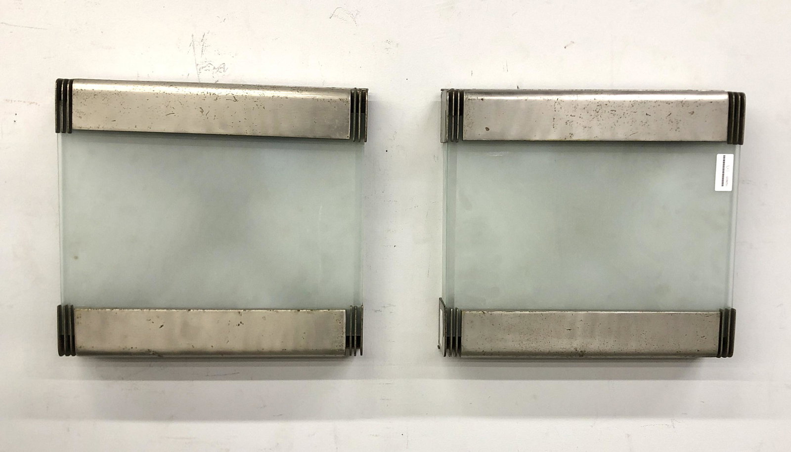 Pair of Art Deco style metal & glass wall lights: A pair of Art Deco style white metal and frosted glass panel wall lights height 17in (43cm); width 15 1/2in (39.5cm)Provenance: Property from a Private Bel Air Collection.