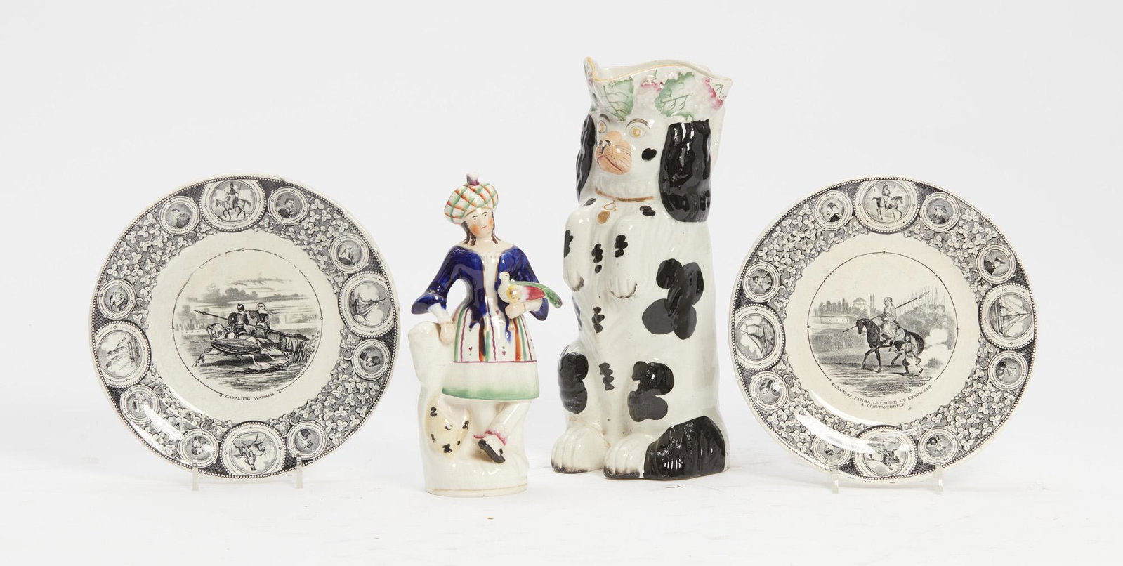 Four Staffordshire and earthenware table articles: An assembled four piece group Staffordshire and earthenware table articlesComprising a pitcher, a figure and two plates. height of pitcher 10in (25.5cm)