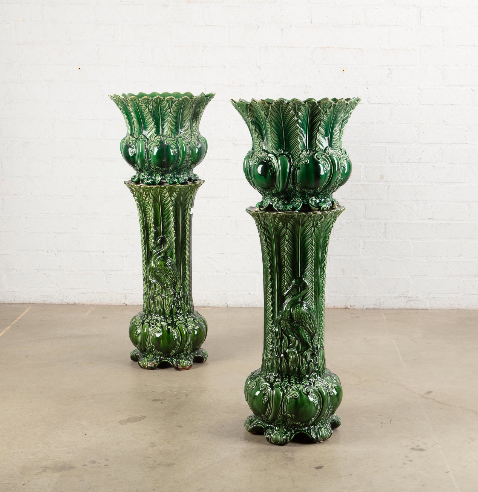 Two Continental green earthenware jardinieres: Two Continental green glazed earthenware jardiniÃ¨res on stands 20th century (4) overall height 44 1/2in (113cm); diameter 16in (40.5cm)