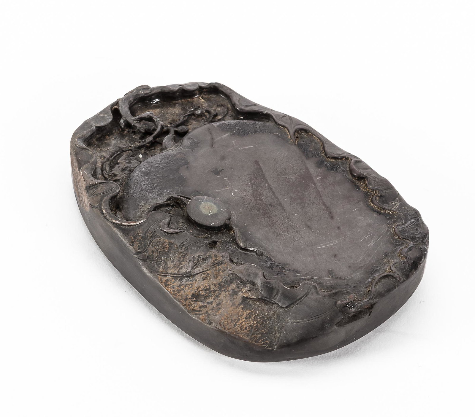 A Chinese inkstone: A Chinese carved inkstone height 1in (2.5cm); width 5 1/2in (14cm); depth 3 3/4in (9.5cm)