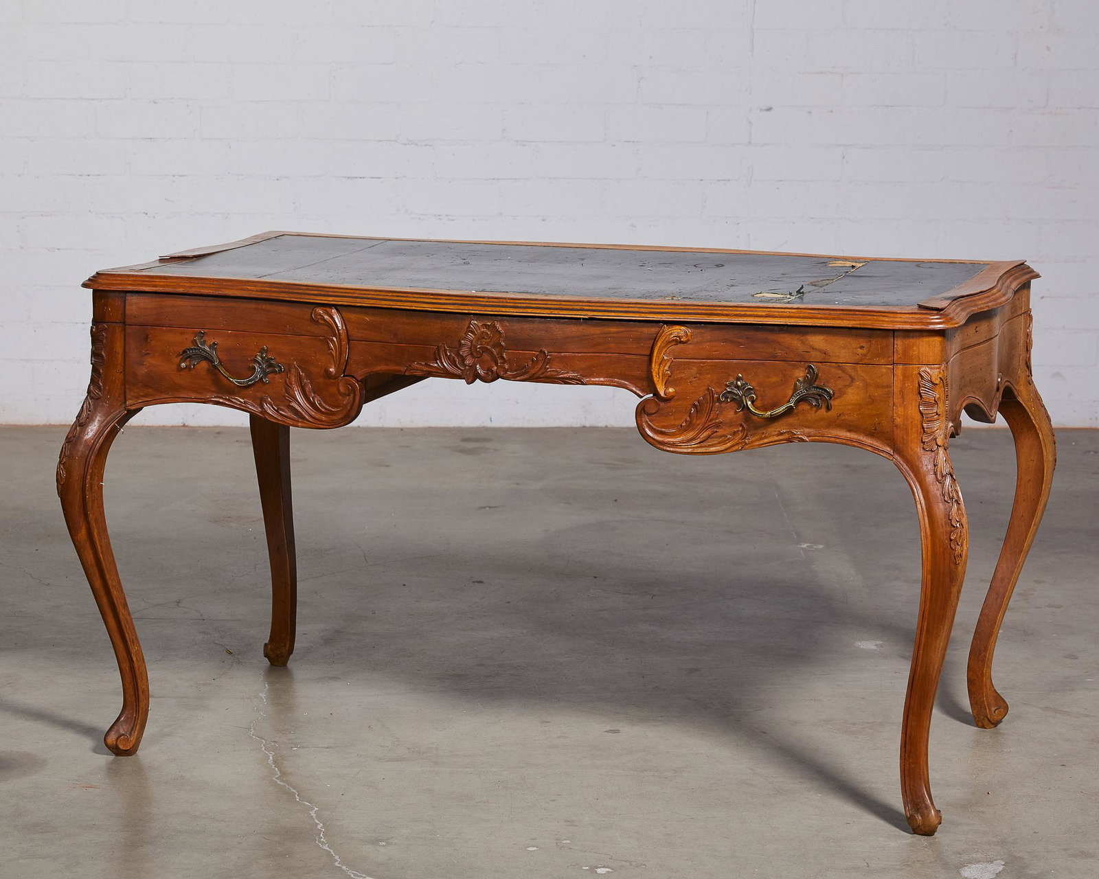 An Italian Rococo style walnut bureau plat: An Italian Rococo style walnut bureau plat early 20th century height 30 3/4in (78cm); width 56 1/2in (143.5cm); depth 31in (79cm) Provenance: Property from the Collection of Fabrizio Mioni, Los A