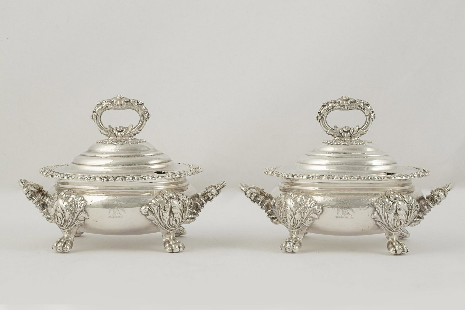 Pair of Old Sheffield plate covered sauce tureens: A pair of Old Sheffield plate covered sauce tureens 19th century Engraved with a heraldic crest. height 6 1/2in (16.5cm); width across handles 8 1/4in (21cm); depth 5 1/4in (13.5cm) Provenance: Proper