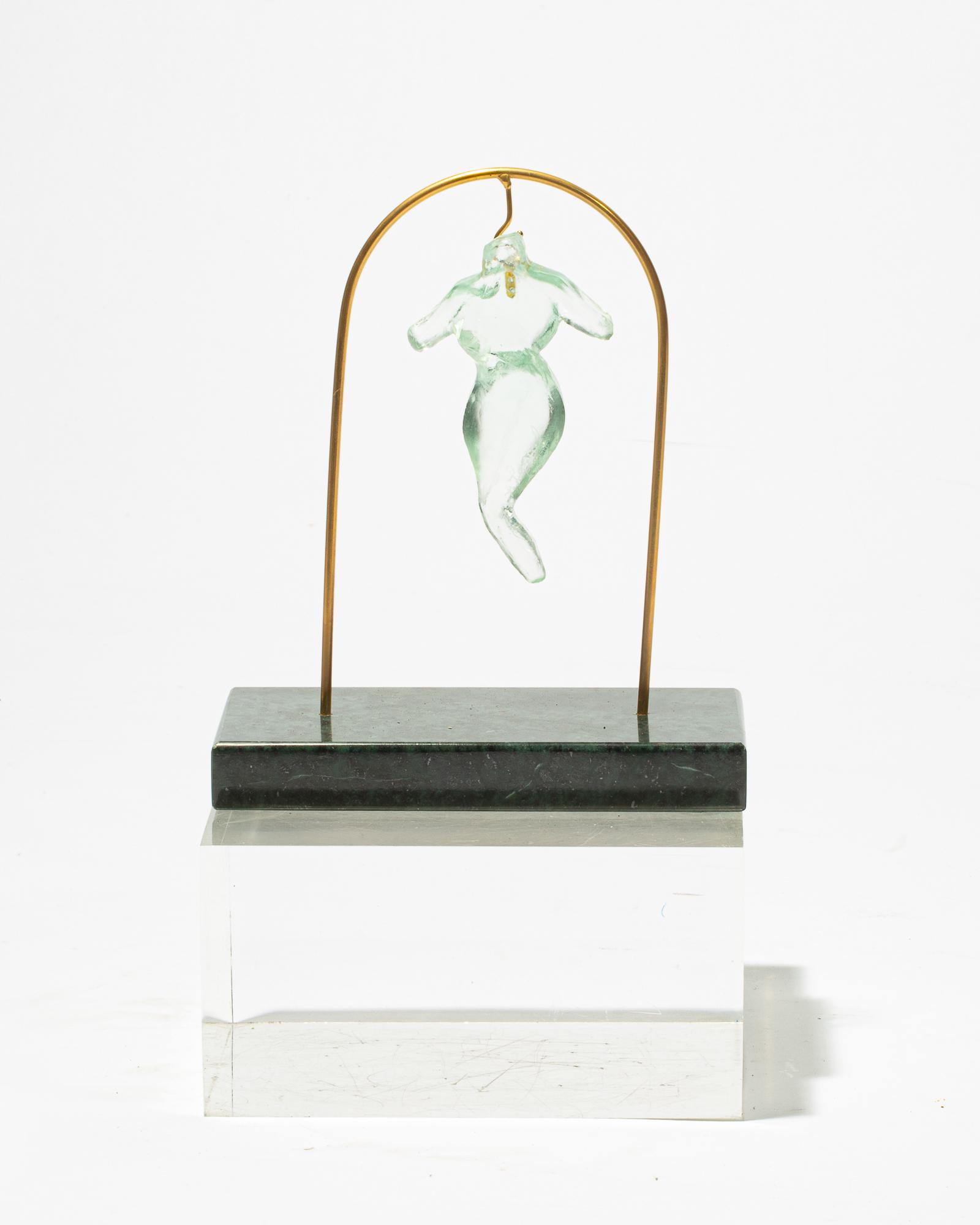 Suzanne Pascal, glass pendant: Suzanne Pascal (American, born 1914) Female torso, abdomen and legs glass pendant Inscribed Pascal, height of glass figure 4 1/2in (11.5cm); width 2 1/4in (5.5cm); depth 1/2in (1.5cm)