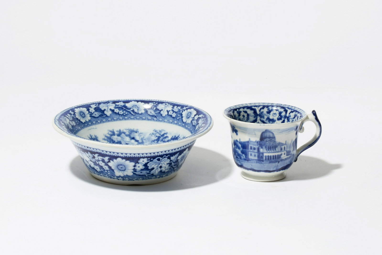 Two Staffordshire tablewares: Boston State House: Two Staffordshire historical blue transfer decorated earthenware tablewares: Boston State House first half 19th century Comprising a bowl and handled cup. height of bowl 2 1/4in (5.5cm); diameter 6 1/