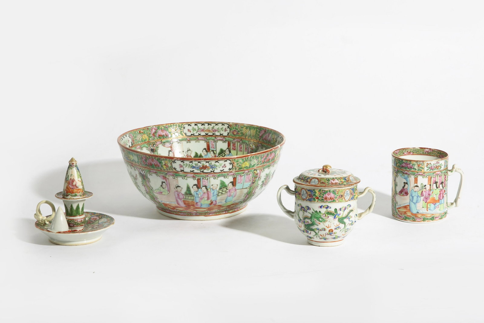 Four Chinese Export porcelain tablewares: A group of Chinese export porcelain Famille Rose Medallion tablewares Comprising a punch bowl, tankard, chamber stick/snuffer and covered two handle cup. (4) height of punch bowl 5in (12.5cm); diamete