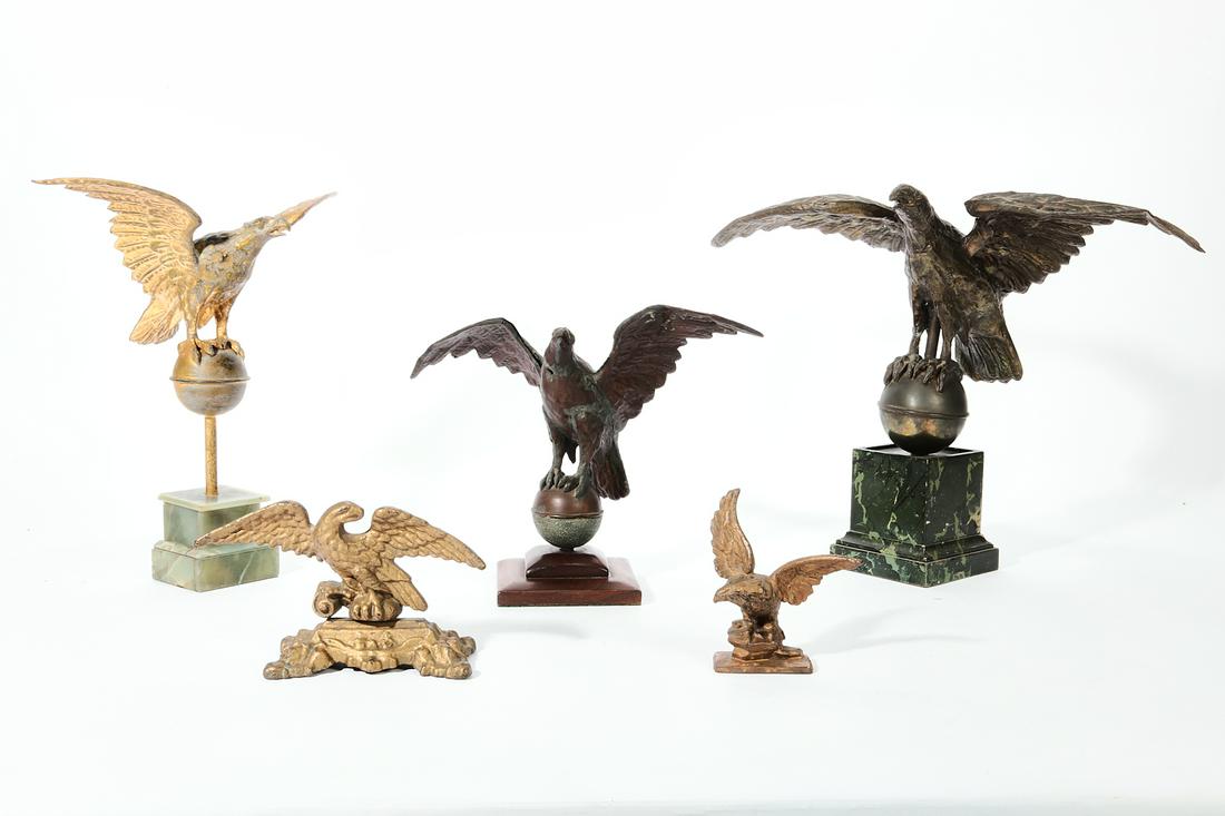 A group of five mixed metal eagles: A group of five mixed metal eagles late 19th-early 20th century Comprising three zinc eagle finials mounted to later bases and two gilded cast iron doorstop/paperweights. (5) height of largest 17 3/4i