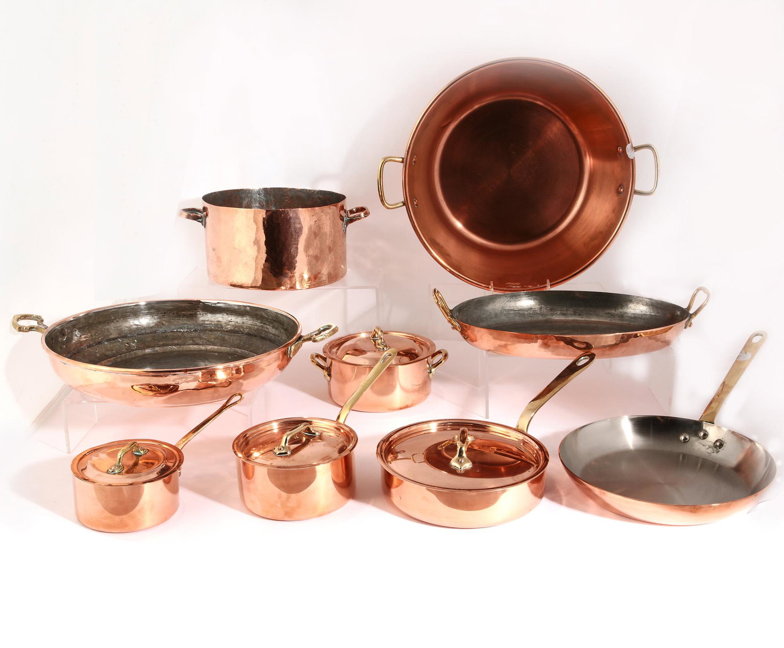 Nine pieces French of copper clad cookware: A nine piece group of French copper and copper clad cookware various makers 20th century largest pot height 5in (12.5cm); width 18in (46cm); depth 14 1/2in (35.5cm) Provenance: Property from a Private