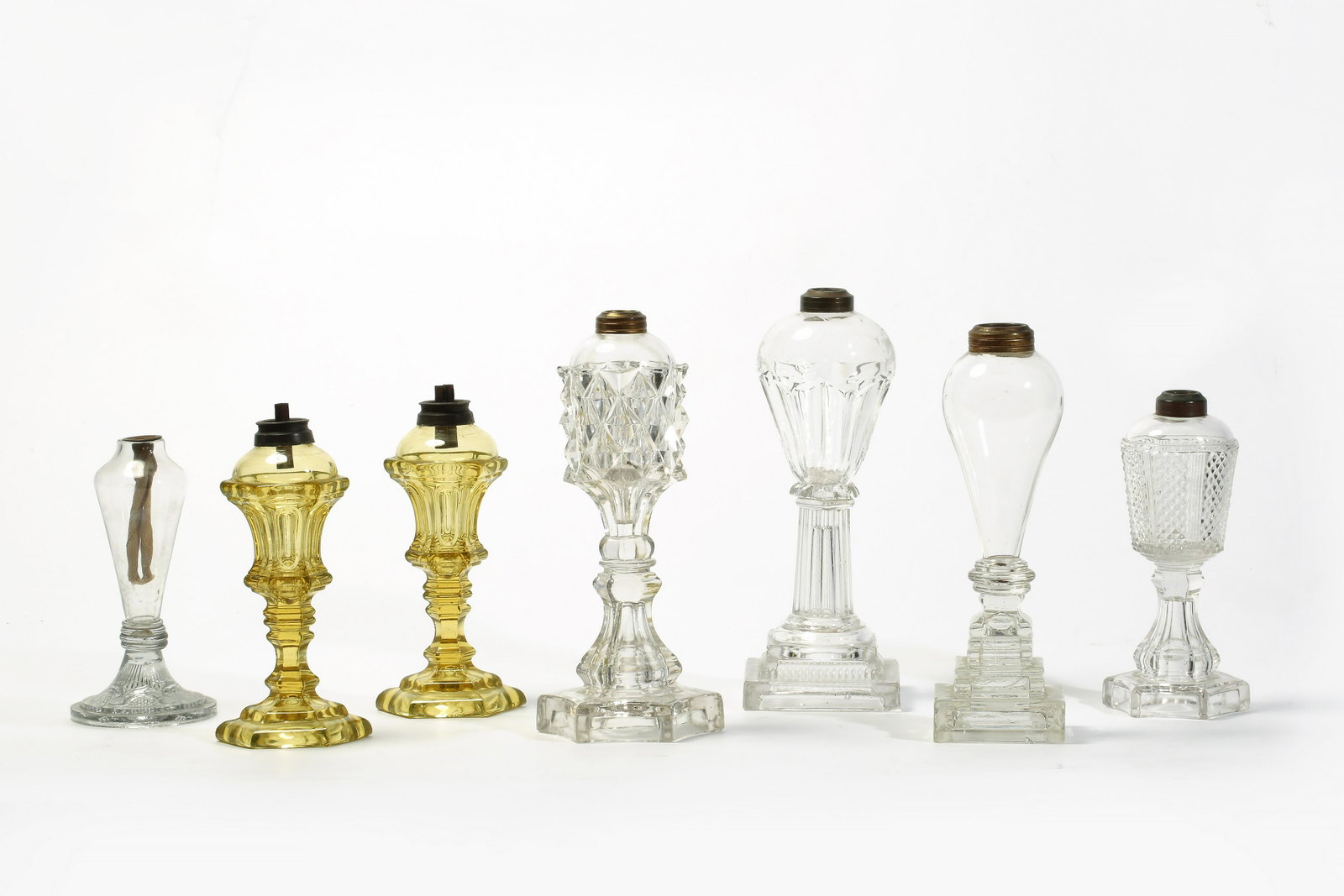 Seven American glass whale oil fluid stand lamps: A group of seven American molded, free-blown and pressed flint glass whale oil / fluid stand lamps probably Boston & Sandwich Glass Company 19th century Comprising a pair of vaseline lamps and five co