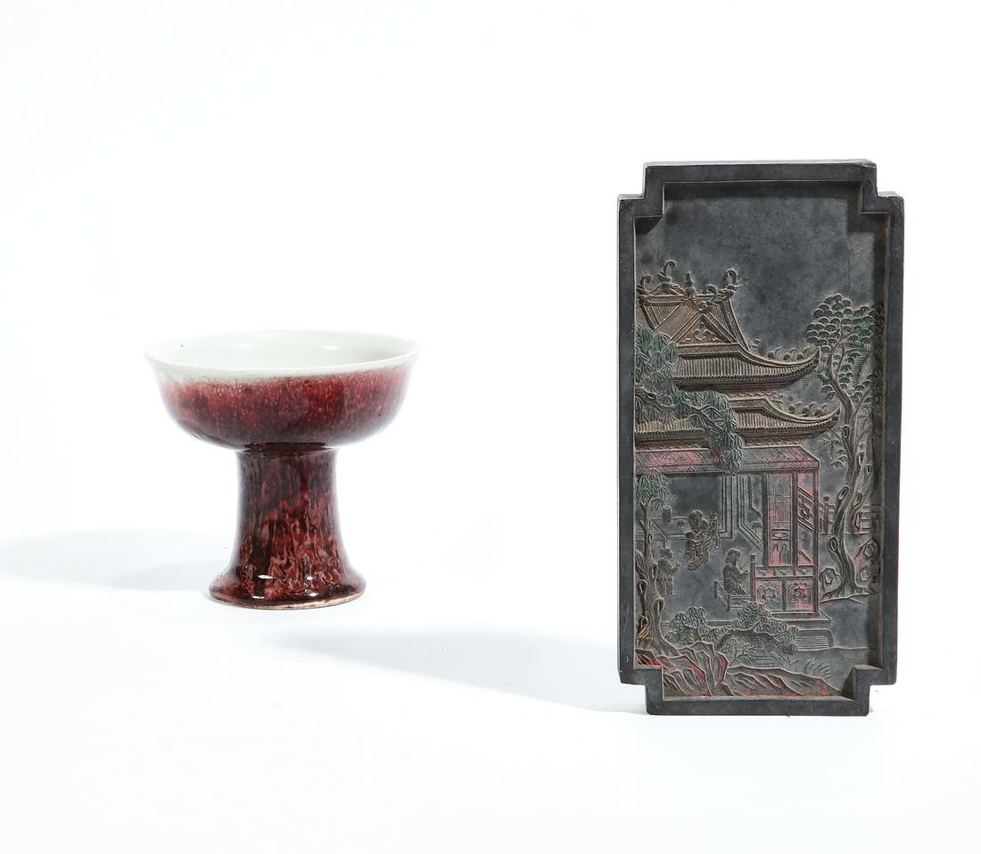 A Chinese glazed footed cup and an inkstone: A Chinese red flambe glazed footed cup and an inkstone (2) height of cup 3 3/4in (9.5cm); length of inkstone 7in (18cm)