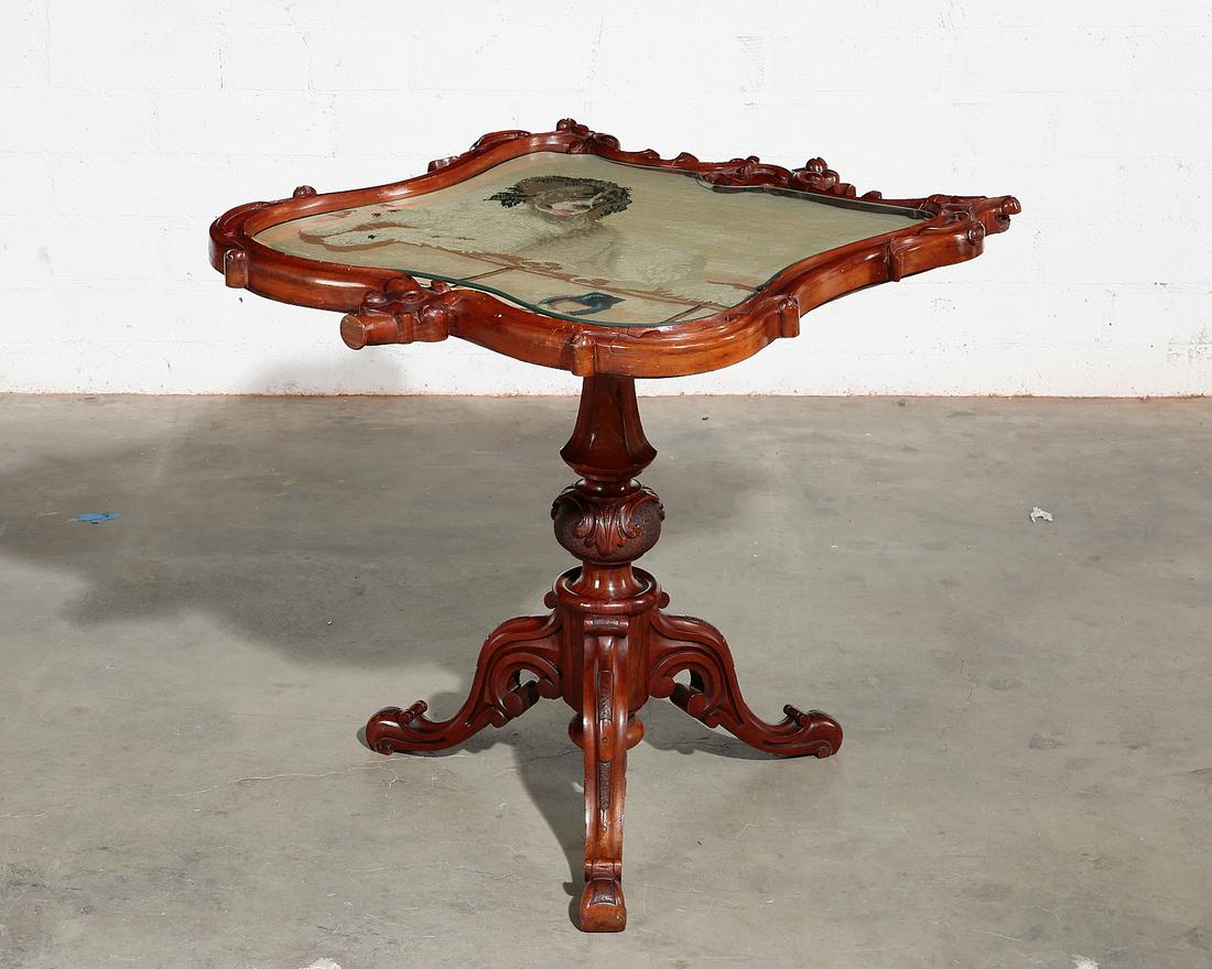 An English walnut and needlework occasional table: An English walnut and needlework occasional table second half 19th century, converted from a pole screen Decorated with a recumbent spaniel, with later inset glass top. height 26in (66cm); width 25 1/