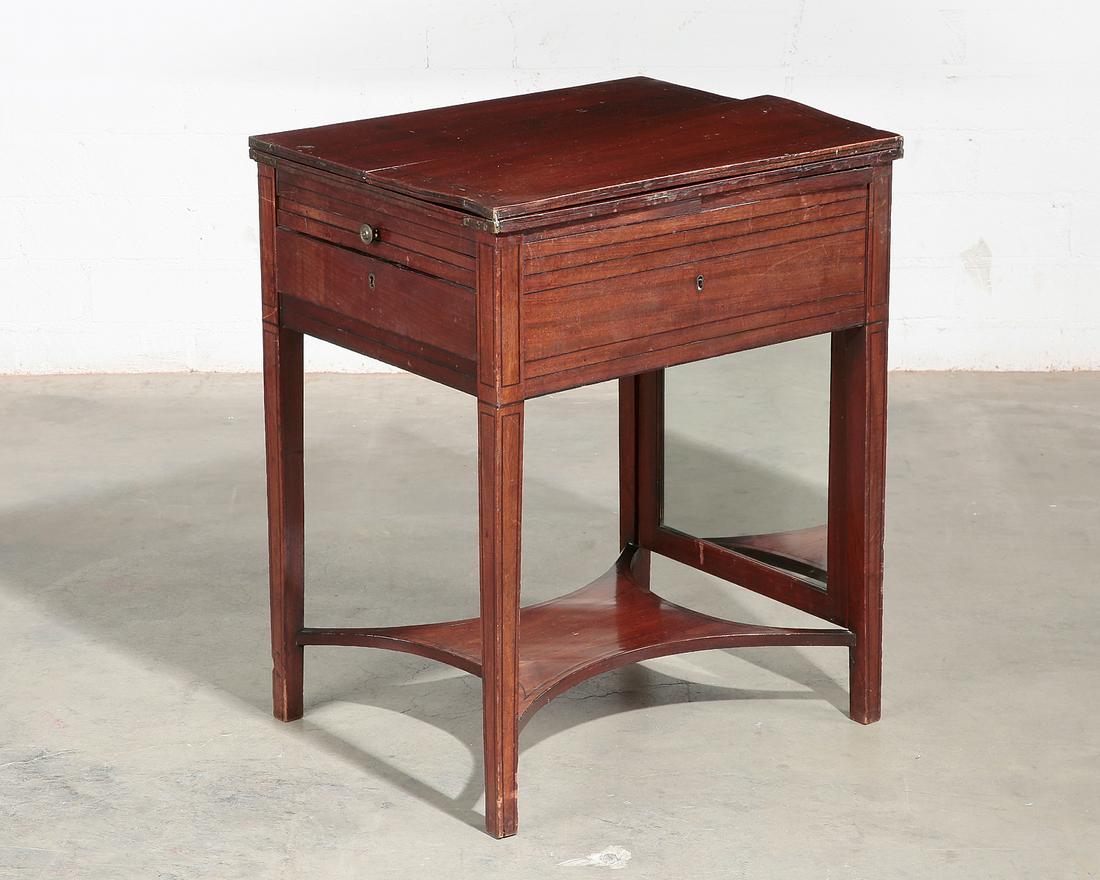 A George III inlaid mahogany dressing table: A George III inlaid mahogany dressing table late 18th/early 19th century The dual hinged top opening to reveal a retractable mirror, having a writing slide and single frieze drawer below. height 26 3/