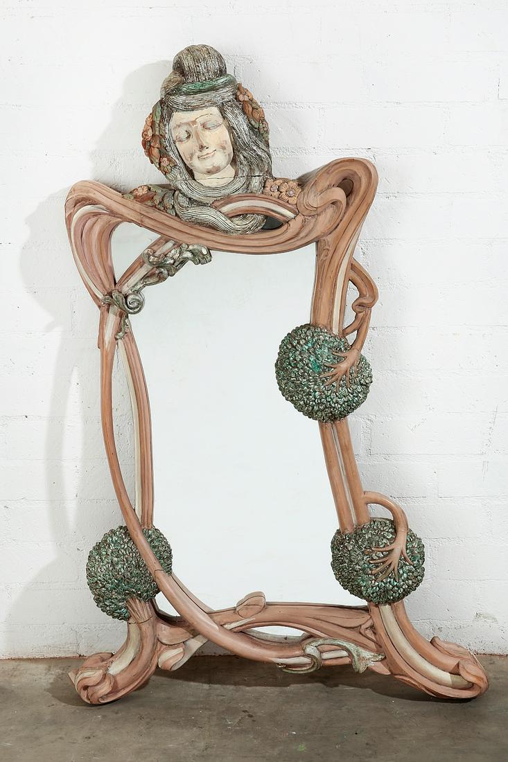 A Art Nouveau style figural mirror: A whimsical Art Nouveau style polychrome decorated carved figural mirror post 1950 height 55in (139.5cm); width 35in (89cm); depth 4 1/2in (11.5cm)