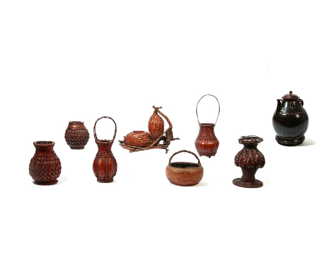 Eight Asian woven and ceramic decorations: A group of eight Asian woven and ceramic table decorations Comprising a glazed earthenware vessel with hardwood lid and base and six various wicker vessels. the largest overall height 18in (47cm) Prov