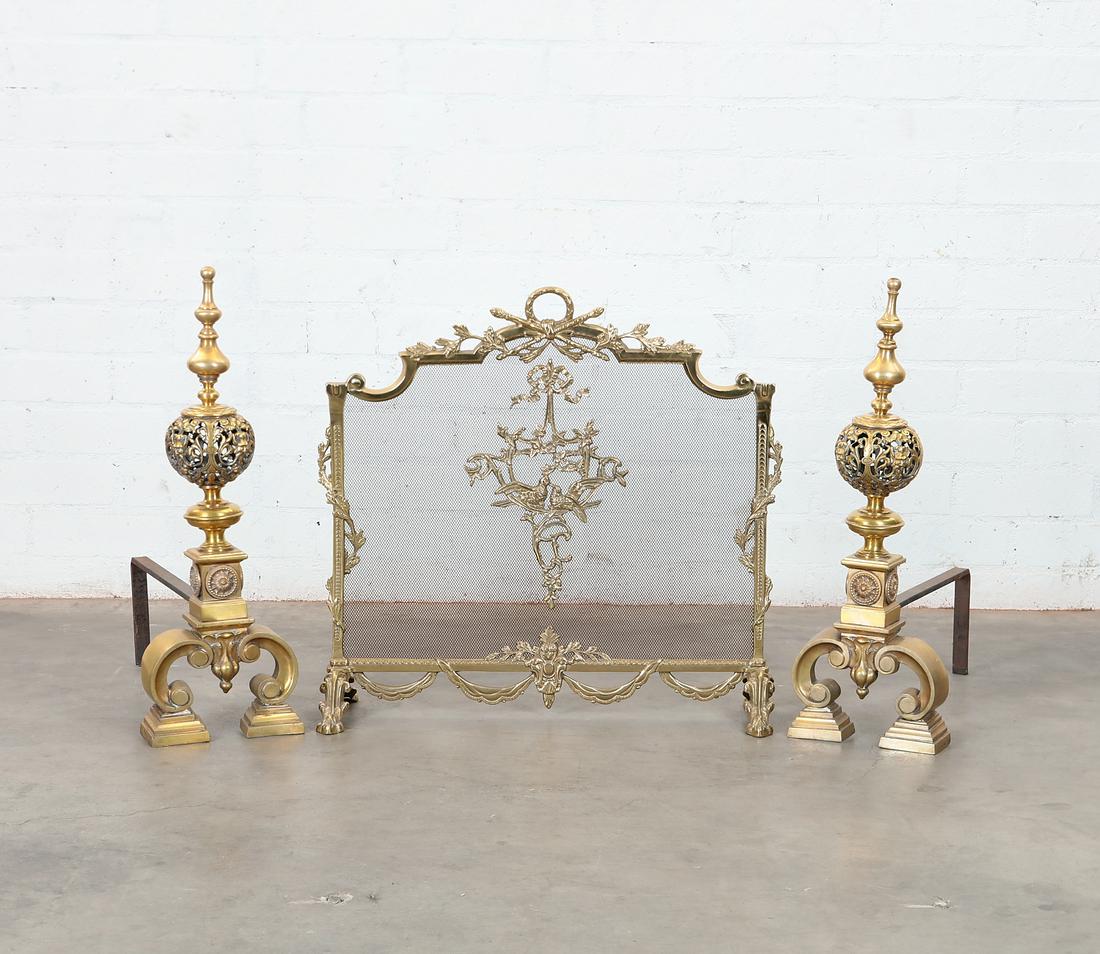 A set of three Baroque style brass fire tools: A set of three Continental Baroque style brass fire tools Comprising a pair of andirons and a fire screen. Provenance: Property from the Estate of June Ebensteiner, Westlake Village, California.