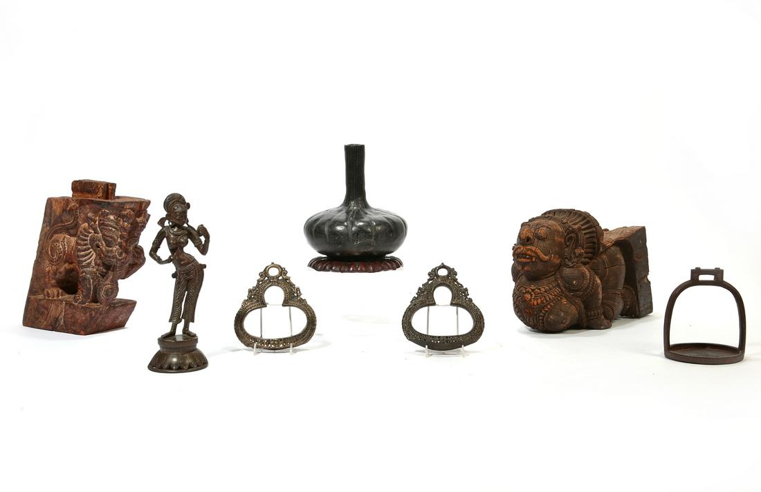 A group of seven Asian table decorations: A group of seven Asian table decorations Comprising two carved wood brackets, a pair of metal stirrups, a single iron stirrup, an Indian bronze figure and an earthenware vase on hardwood base. the lar